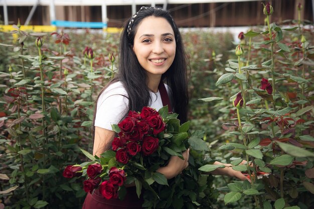 Operaio di fiori in serra che raccoglie rose