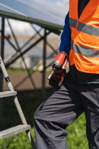 Operaio di una centrale solare con un trapano avvitatore in mano