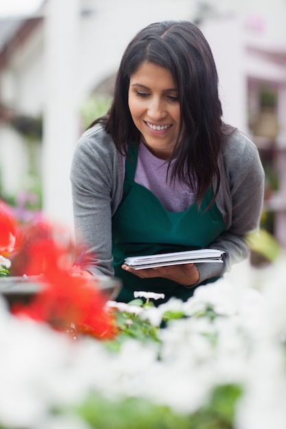 Operaio guardando i fiori e prendere appunti