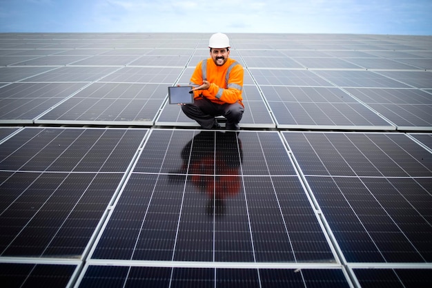 Operaio industriale a energia solare che esegue il controllo di qualità dei pannelli fotovoltaici installati in fabbrica