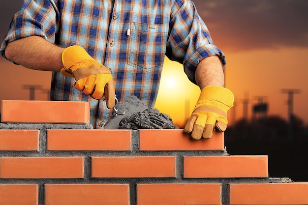 Operaio industriale muratore che installa muratura in mattoni