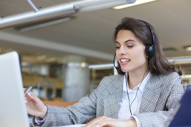 Operatore di assistenza clienti donna con auricolare e sorridente.