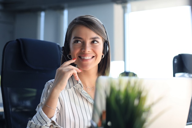 Operatore di assistenza clienti femminile con auricolare e sorridente.