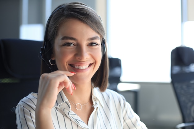 Operatore di assistenza clienti femminile con auricolare e sorridente.