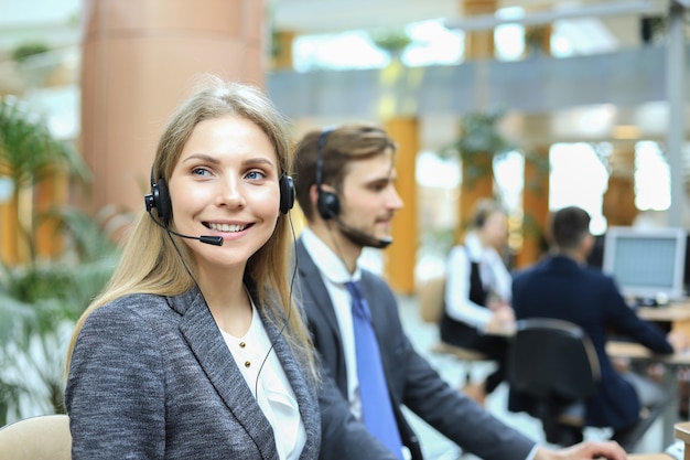 Operatore di assistenza clienti femminile con auricolare e sorridente.