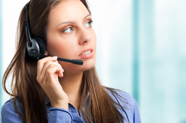 Operatore di call center femminile sorridente isolato su bianco