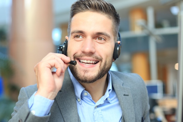 Operatore di call center maschio giovane bello sorridente amichevole.