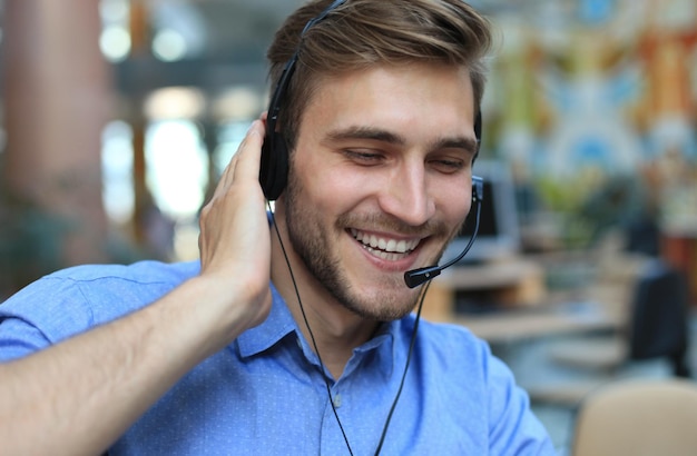 Operatore di call center maschio giovane e bello sorridente amichevole