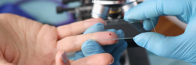 Operatore di laboratorio che preleva sangue dal dito femminile per indagine