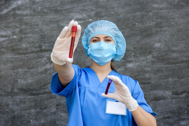 Operatore medico che tiene la provetta rossa e la guarda in laboratorio