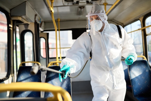 Operatore sanitario che disinfetta autobus pubblico al fine di prevenire la diffusione del COVID19