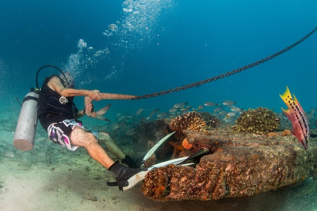 Operatore subacqueo che tiene l'ancora della barca da sott'acqua