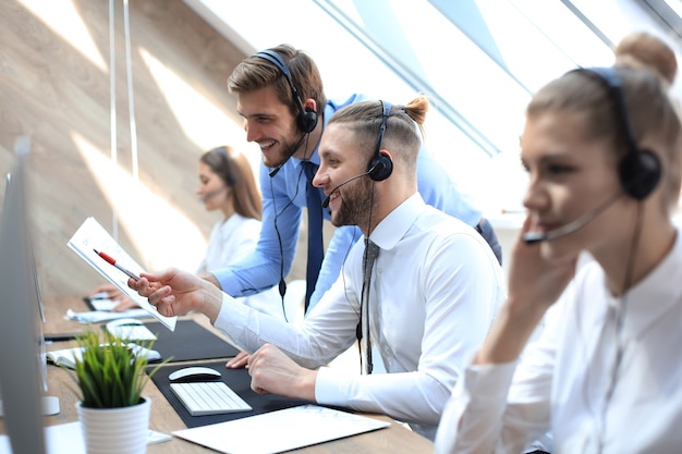 Operatore telefonico che lavora presso l'ufficio del call center aiutando il suo collega.