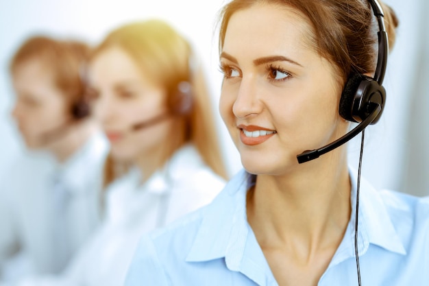 Operatori di call center. Concentrarsi sulla bella donna d'affari in cuffia.