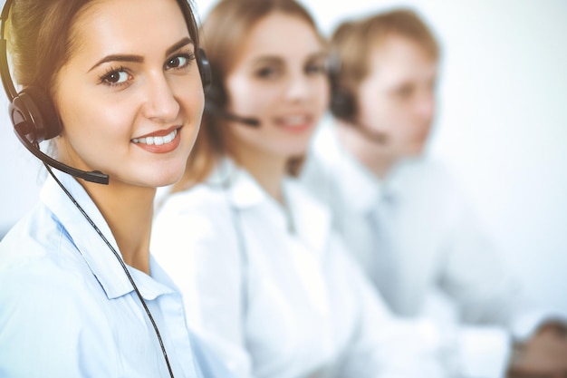 Operatori di call center. Concentrarsi sulla bella donna d'affari in cuffia.