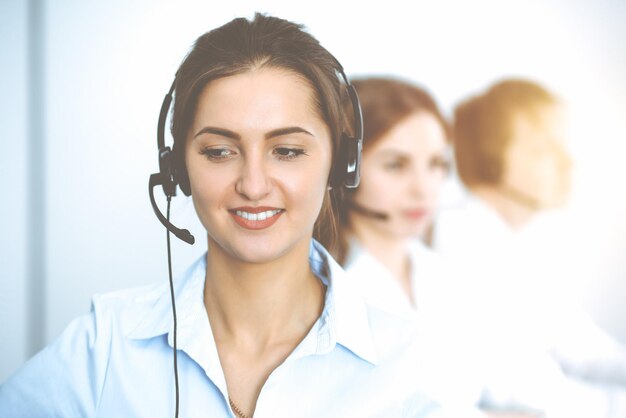 Operatori di call center. Concentrarsi sulla bella donna d'affari in cuffia.