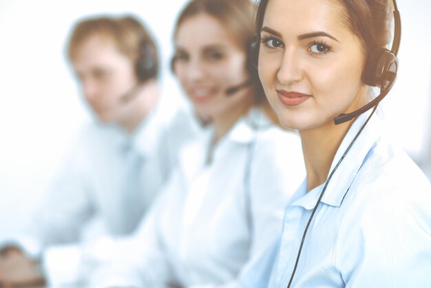 Operatori di call center. Concentrarsi sulla bella donna d'affari in cuffia.