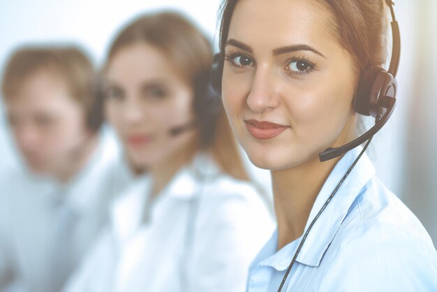 Operatori di call center. Concentrarsi sulla bella donna d'affari in cuffia.