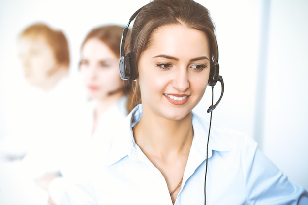 Operatori di call center. Concentrarsi sulla bella donna d'affari utilizzando l'auricolare.