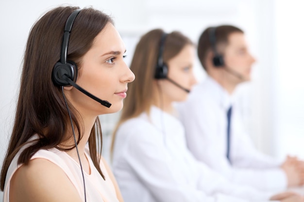 Operatori di call center Concentrarsi sulla giovane e bella donna d'affari in cuffia