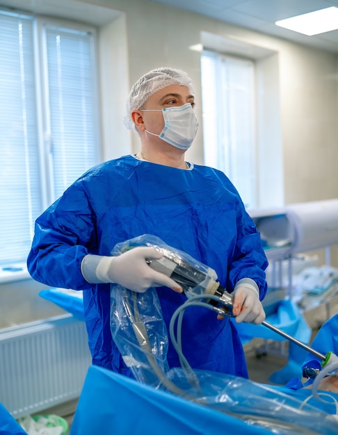 Operazione di chirurgia penforming medico con attrezzature moderne. Medico specialista in camici. Interno moderno dell'ospedale.