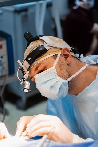 Operazione di chirurgia plastica di blefaroplastica per modificare la regione oculare del viso in clinica medica Il chirurgo fa un'incisione con un coltello chirurgico