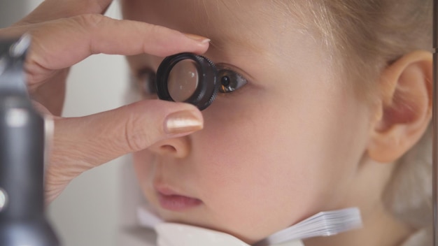 Optometrista che controlla il colpo a macroistruzione di visione del piccolo bambino