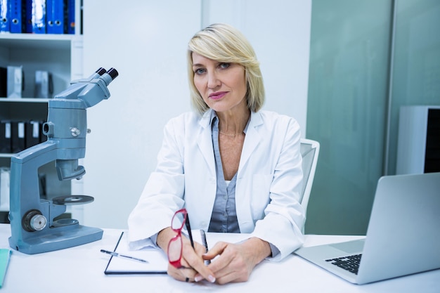 Optometrista che si siede nella clinica di oftalmologia