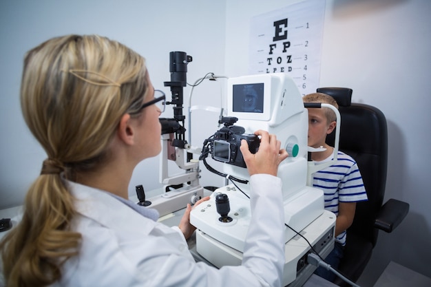 Optometrista femmina che esamina giovane paziente su coreometria