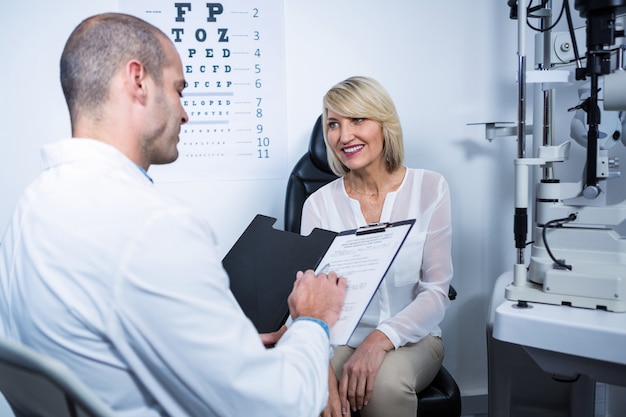 Optometrista maschio che parla con paziente femminile