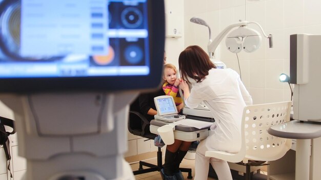 Optometrista sanitario nella clinica di oftalmologia che controlla la visione del bambino piccolo