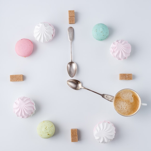 È ora di bere il caffè. un orologio a forma di caffè. macarons, zucchero, marshmallow. lavoro creativo e creativo.