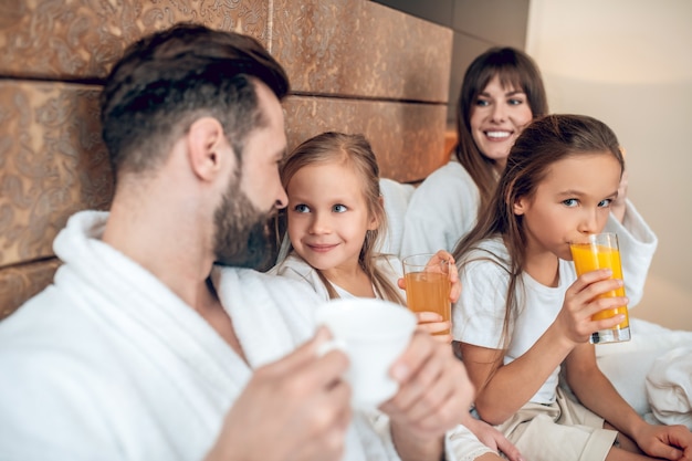 Ora di colazione. Ragazze che bevono succo d'arancia e che sembrano felici