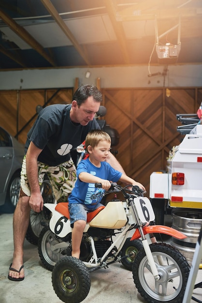 È ora di provare la bici Ripresa di padre e figlio che riparano una bicicletta in un garage