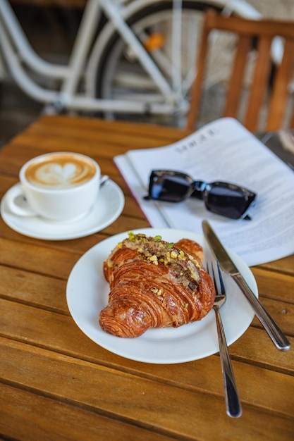Orario della colazione con caffè croissant e rivista nella caffetteria