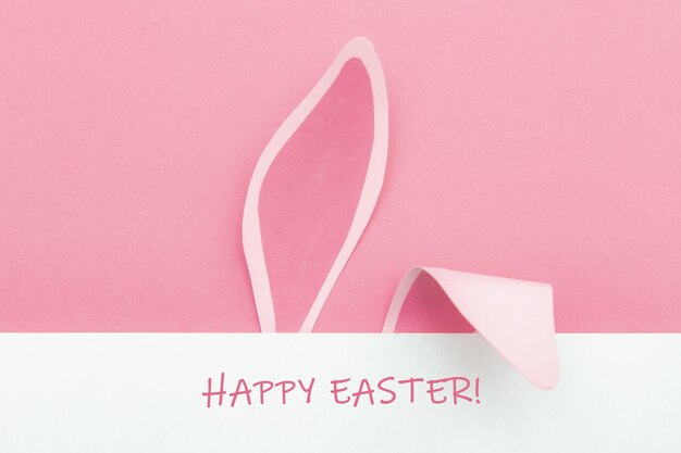 Orecchie da coniglio su sfondo rosa con la scritta Happy Easter Easter card minimalismo