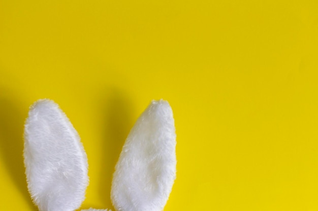 Orecchie di coniglio di peluche su sfondo giallo Concetto di Pasqua con un posto da copiare