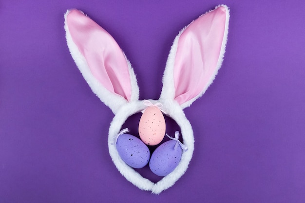 Orecchie e conigli di coniglio di carnevale con la decorazione su una superficie viola