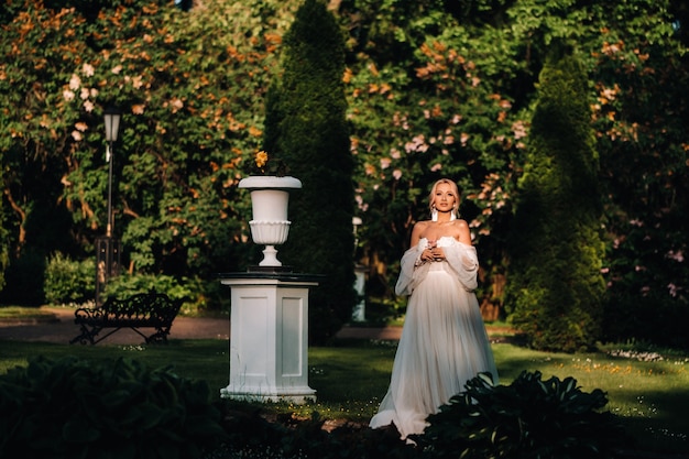 Orecchini da sposa su una mano femminile, prende gli orecchini, le tasse della sposa, la sposa mattutina, il vestito bianco, indossa gli orecchini