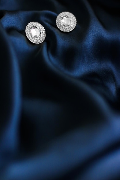 Orecchini di diamanti di lusso su sfondo di seta blu scuro regalo di gioielli glamour per le vacanze
