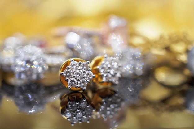 Orecchini di diamanti gioielli in oro di lusso con la riflessione su sfondo nero
