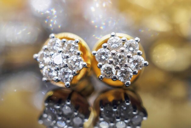Orecchini di diamanti gioielli in oro di lusso con riflesso su sfondo nero