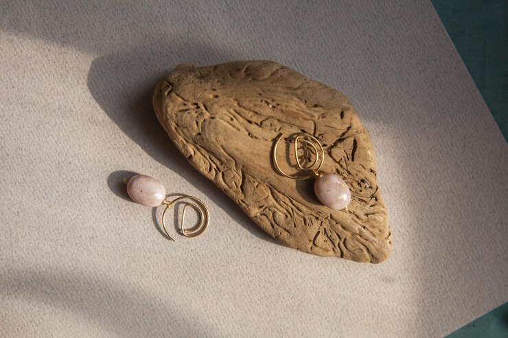Foto orecchini eleganti fatti di pietra opale rosa naturale con accessori in ottone dorato pezzo di legno