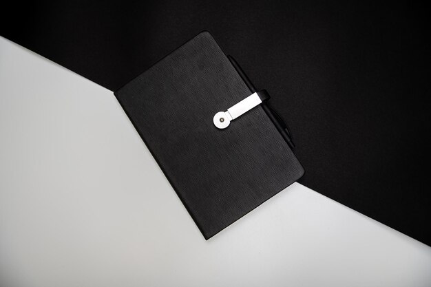 Organizer o taccuino nero con penna su uno spazio di copia mockup di sfondo bianco e nero a due colori
