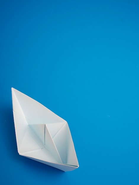 Origami concetto di business Carta bianca barca minima su sfondo blu