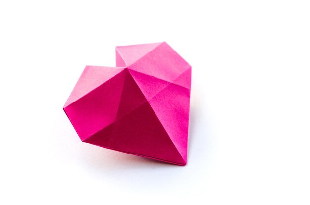 Origami cuore di carta rosa isolato su sfondo bianco