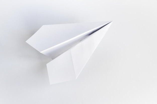 Origami di aeroplano di carta isolato su uno sfondo bianco vuoto