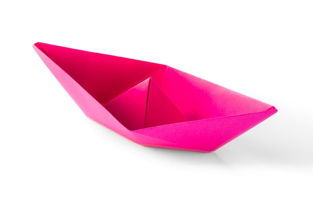 Origami di barchetta di carta rosa isolato su sfondo bianco