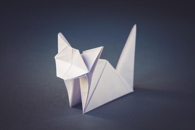 Origami di gatto di carta bianca isolato su sfondo grigio