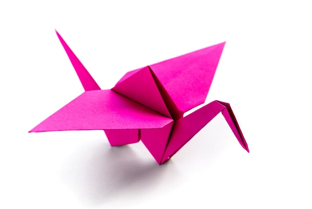 Origami di gru di carta rosa isolato su sfondo bianco